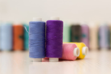 Sewing threads on wooden background