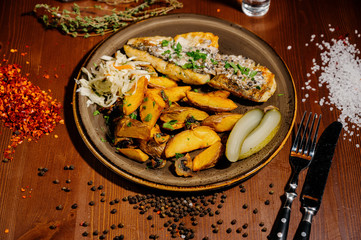 fried potatoes with meat on a plate on a wooden table.Top view