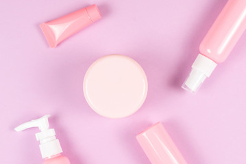 Pink plastic bottles for hygiene products, cosmetics, hygiene products on a pink background.