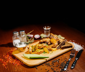 Barbecue grilled chicken wings close up with fries, sauce on wooden background. Meat food concept.