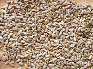 Sunflower seeds peeled on a wooden table, top view.