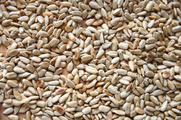 Sunflower seeds peeled on a wooden table, top view.
