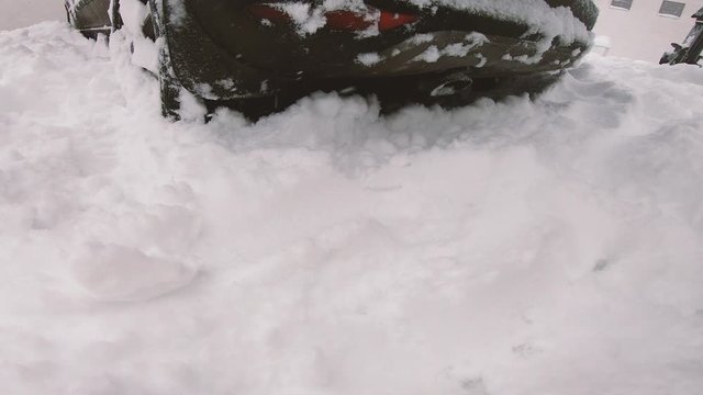 Woman removing deep snow with a showel to free up a car from snow in the early morning, winter deep snow. Fast Shovel