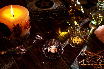 Esoteric or mystical still life with a box and a few burning candles, a pentagram. Pendulum and precious stones on old table