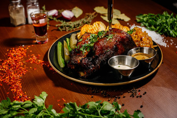 A juicy piece of fried meat lies on a cutting board against a wooden table.