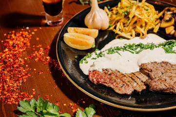 Tasty fragrant pork chops served in a creamy cheese sauce in a pan on the table.