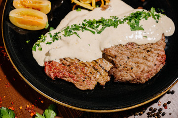 Tasty fragrant pork chops served in a creamy cheese sauce in a pan on the table.