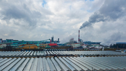 Aerial view greenhouse on the background of smoke from the pipes of the pulp mill. Ecological problem concept.