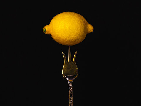 Fresh Lemon On A Silver Dessert Fork In The Shape Of A Crown. Prevention From The Virus. Health Life With Fruit, Concept.