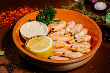 Grilled shrimps or prawns served with lemon and sauce