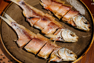 Group of dried fish at plate . Seafood