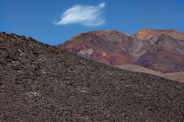 Geometric composition of rock formations in the Death Valley National Park, strong contrast of colours, dark greys in the foreground, brown shades in the background