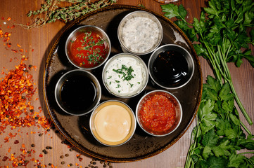 Different types of sauces and oils in bowls, top view