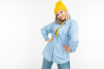 blond girl in a stylish denim shirt and a yellow jacket on a white background