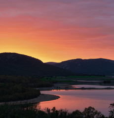 Fototapeta premium Sunset over a lake with reflections