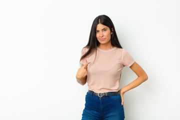 young pretty latin woman looking proud, confident and happy, smiling and pointing to self or making...