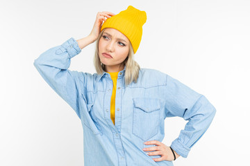close-up of a pensive girl model in a stylish denim shirt with a blonde haircut on a white studio background