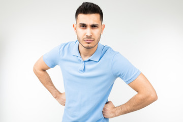 brunette man in a blue t-shirt is angry on a white isolated background