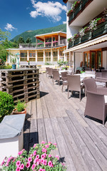 Fototapeta na wymiar Street restaurant with umbrellas tables and chairs Bad Kleinkirchheim with flowers