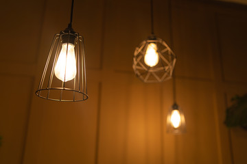 Stylish loft lamps in dark room. From below of modern lamps with geometric decoration in trendy loft dark room