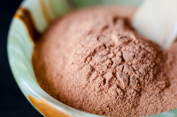 Red bentonite clay powder in the onyx bowl. Diy facial mask and body wrap recipe. Natural beauty treatment and spa. Clay texture closeup, selective focus.