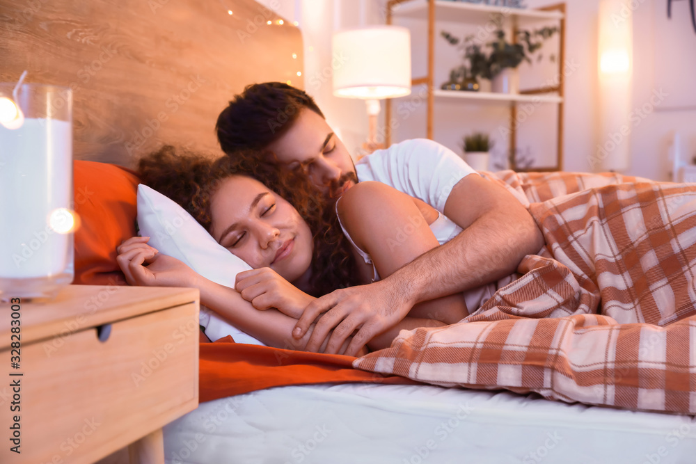 Wall mural happy young couple sleeping in bed at night