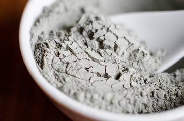 Gray bentonite clay powder in a bowl. Diy facial mask and body wrap recipe. Natural beauty...