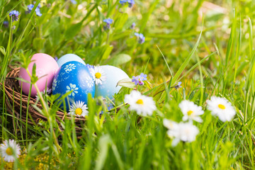 Happy Easter  -  Nest with easter eggs in grass on a sunny spring day - Easter decoration background