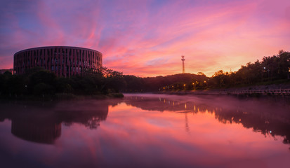 In the early morning of the city, the sky is full of rosy clouds, and the advection fog flows around the river, hazy and beautiful