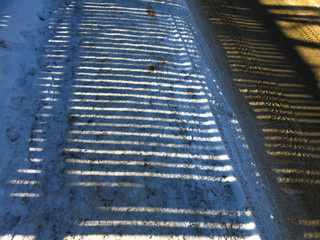 graphic shadow on snow from a vertical fence