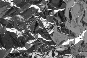 Crumpled silver glossy foil texture. Abstract gray wrinkled sheet pattern, above