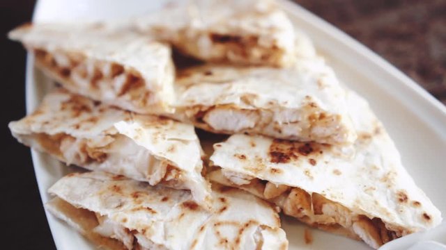 Closeup of slliced chicken quesadilla  - video in slow motion