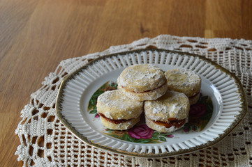 Serbian homemade vanilla cookies, vanilice, on the round vintage plate, in background is traditional crocheted tablecloth 