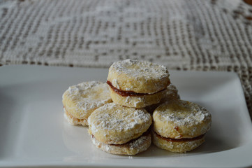Serbian homemade vanilla cookies, vanilice, on the white plate, in background is traditional crocheted tablecloth 