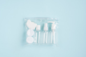 Plastic containers. Travel set on a blue background.  Plastic bottles for cream, shampoo, lens...