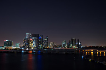 Fototapeta na wymiar Miami city skyline panorama at dusk with urban skyscrapers and bridge over sea with reflection