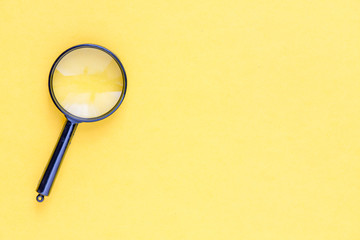 close up magnifier glass on yellow background 