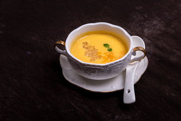 Sweet soup in a white cup against a dark background