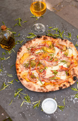 Rustic Italian pizza with rosemary and potato served with white wine