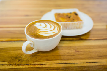 Latte coffee cup on wooden table, selective focused image of hot coffee drink