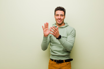 young arabian man feeling happy and successful, smiling and clapping hands, saying congratulations...