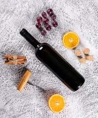 Fototapeta na wymiar Top view of red wine with grape, orange and cinnamon on white stone background horizontal