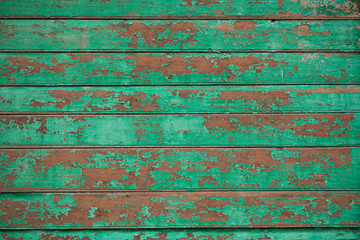 wooden planks covered with green old peeling paint background