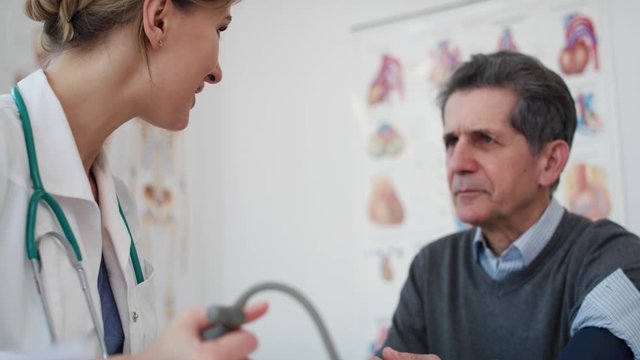 Handheld view of doctor measures pressure in his patient. Shot with RED helium camera in 8K
