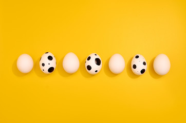 Many White eggs with green myrtle leaves pattern on yellow color background. Spring and Easter...