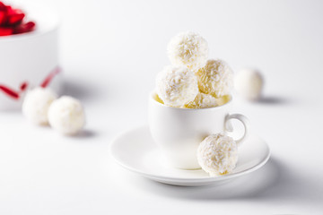coconut candy in a tea cup on a white background