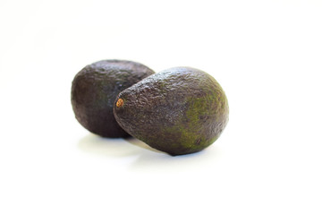 Two avocado fruits on a white isolated background.