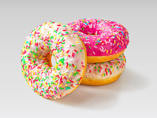 Three glazed doughnuts on a light background
