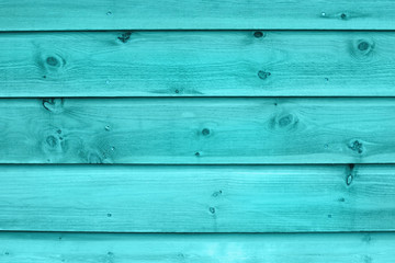 Fototapeta premium Texture of a fragment of a wooden house wall. The wall is painted turquoise color