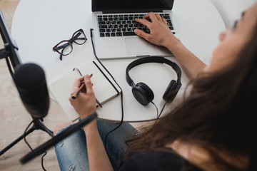 Woman blogger recording radio podcast in studio.